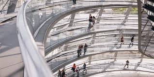 Visitors walking the spiral ramp of a modern parliamentary glass dome